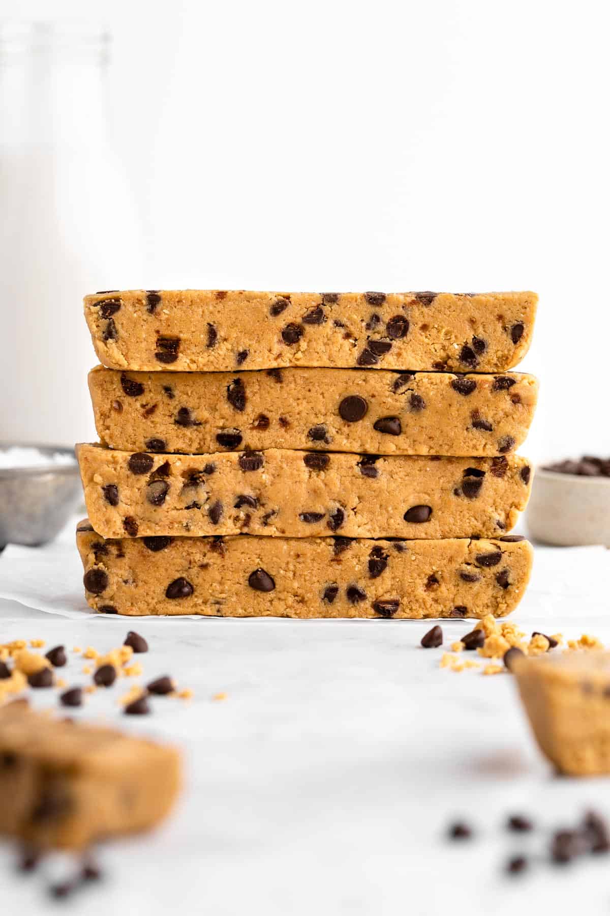 a stack of four homemade vegan cookie dough protein bars with chocolate chips