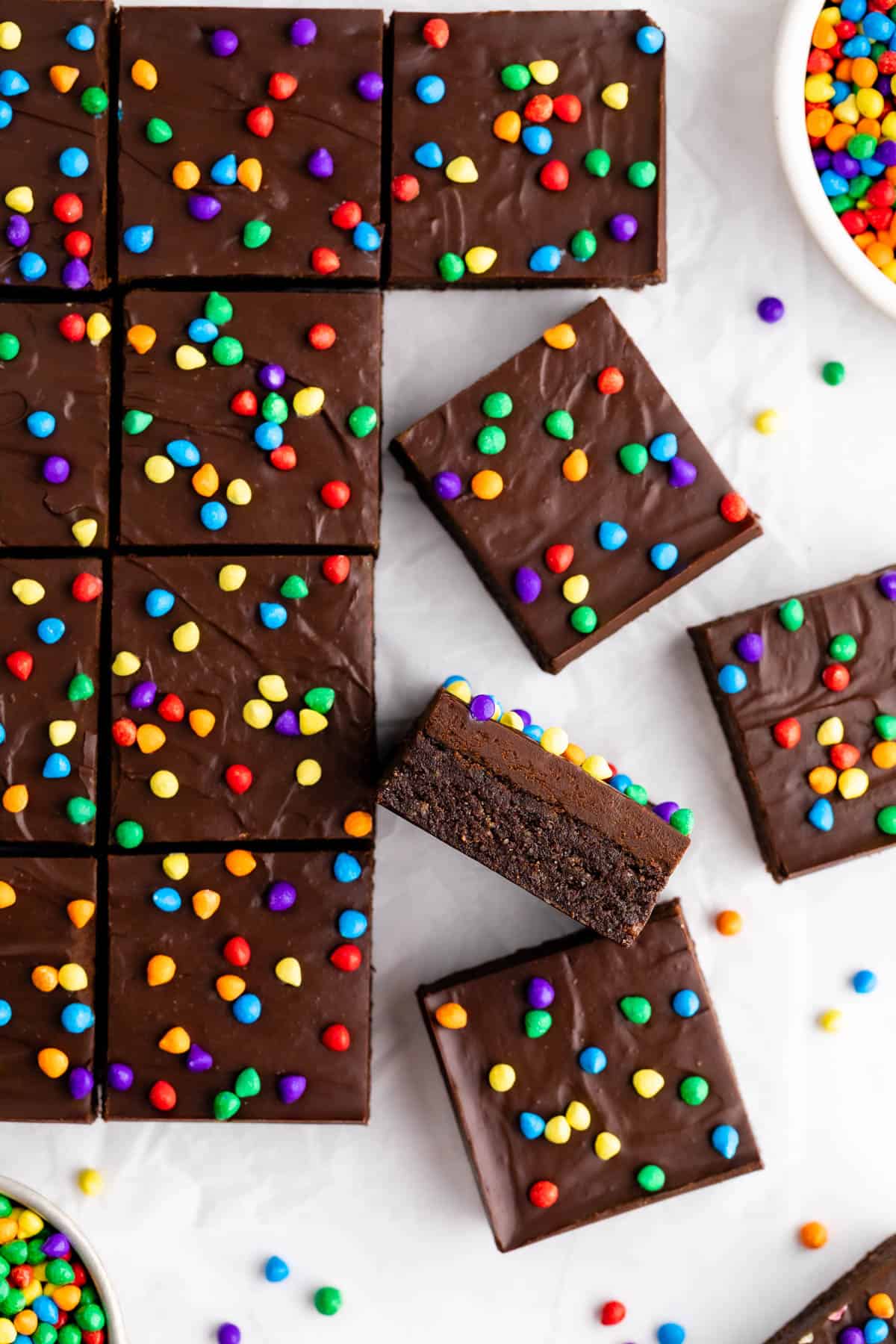 a pile of no-bake vegan cosmic brownies with rainbow chips