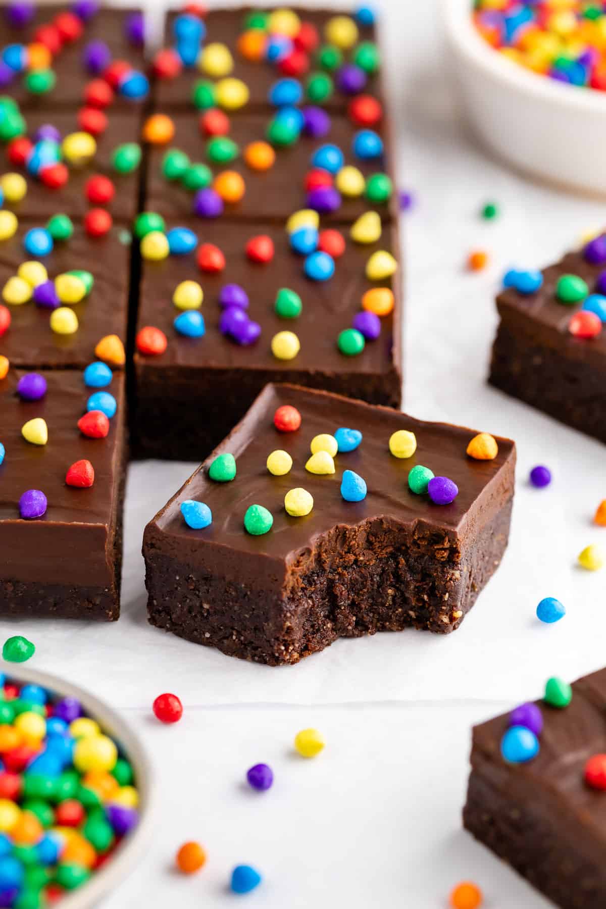 no-bake vegan cosmic brownies with a bite taken out of the middle one
