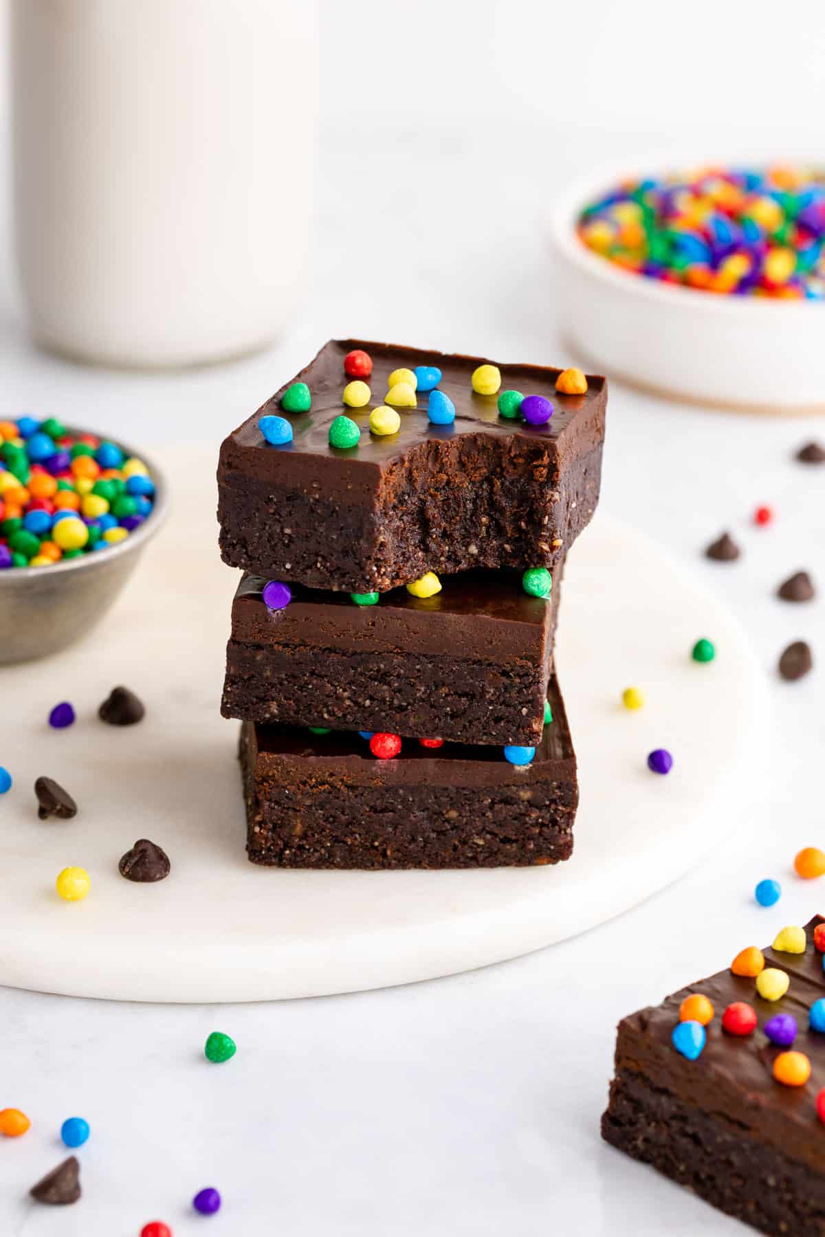 a stack of three homemade vegan cosmic brownies with a bite taken out of the top one