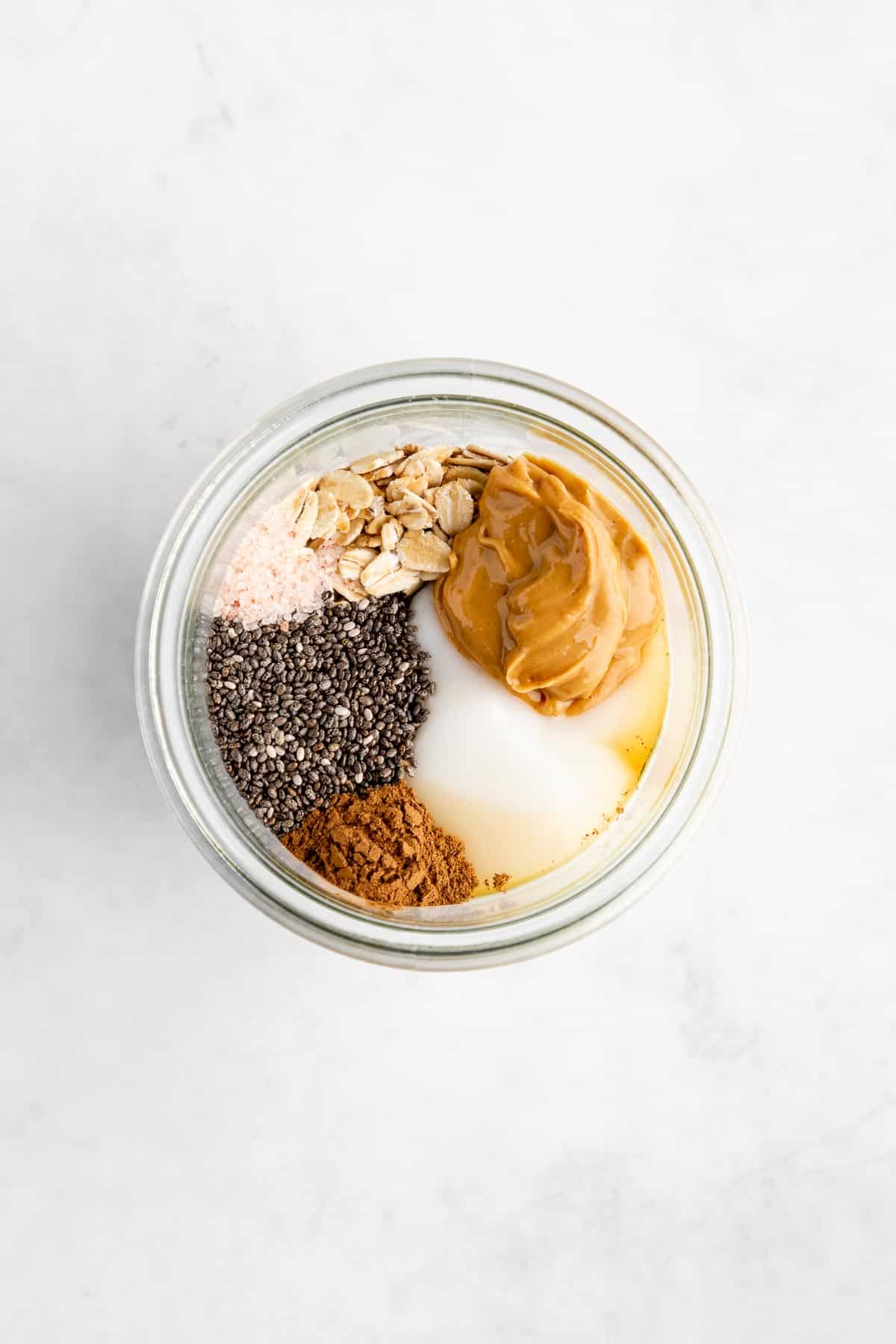 rolled oats, peanut butter, dairy-free yogurt, chia seeds, cinnamon, and maple syrup in a mason jar
