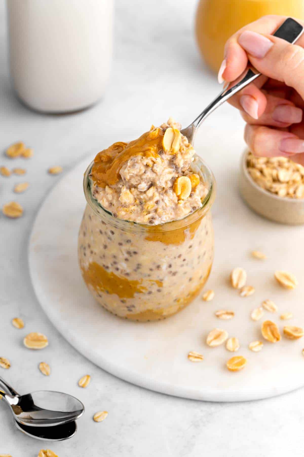 a spoon scooping into a jar of vegan peanut butter overnight oats