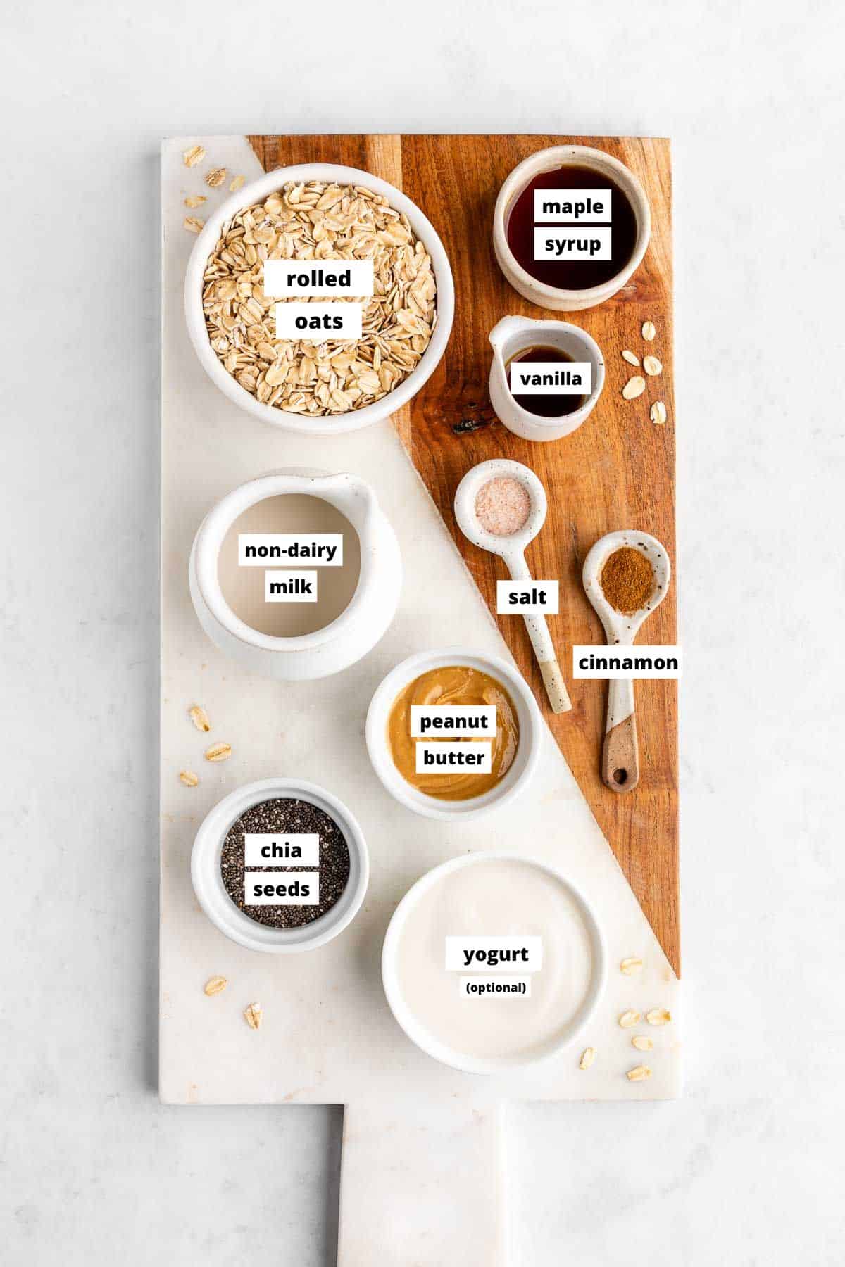 a marble serving board topped with bowls of vegan peanut butter overnight oats ingredients