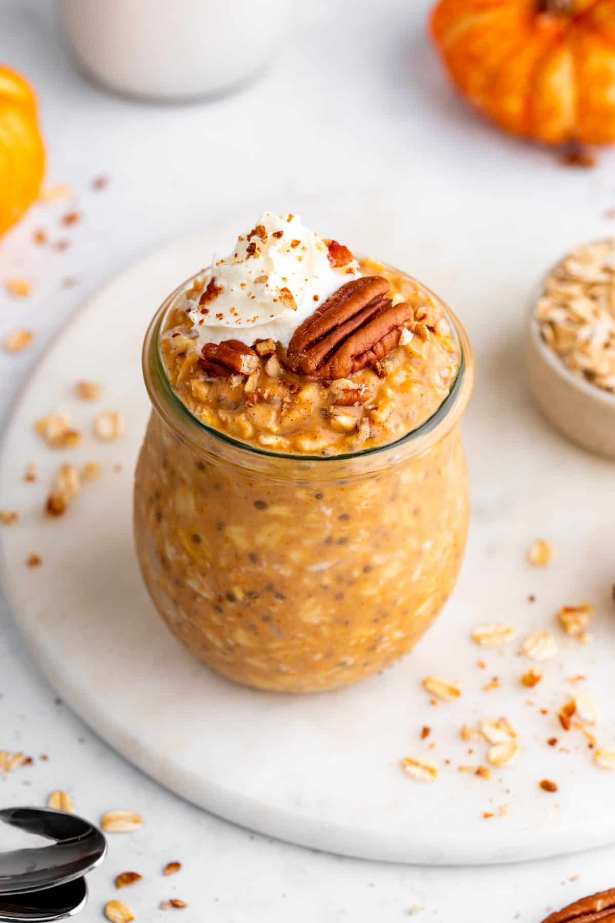 pumpkin pie overnight oats in a glass jar with pecans and chia seeds