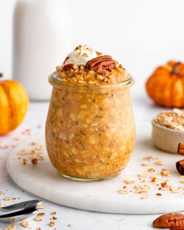 vegan pumpkin pie overnight oats in a jar with whipped cream and pecans