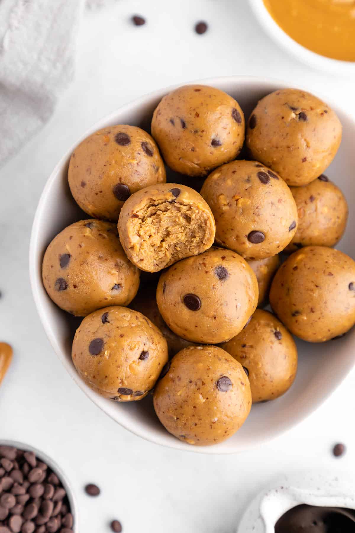 peanut butter protein balls in a bowl with a bite taken out of the middle of one