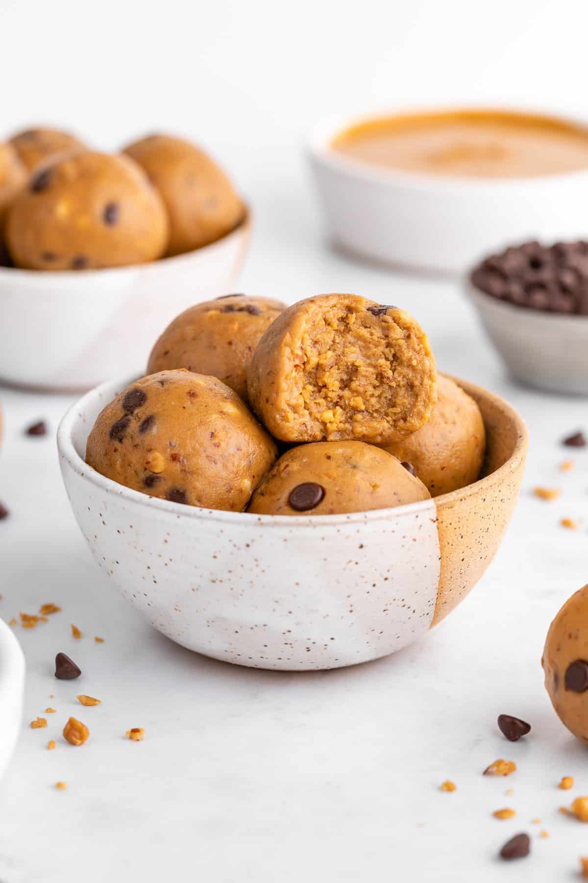 vegan peanut butter protein balls in a ceramic bowl with a bite taken out of it