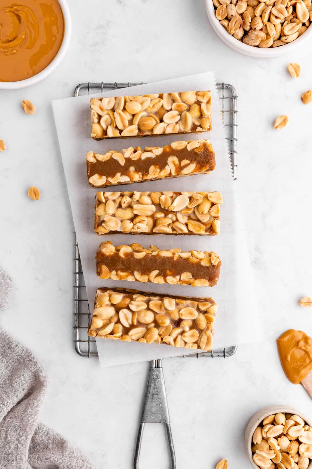 homemade payday bars on a wire rack with peanuts and peanut butter