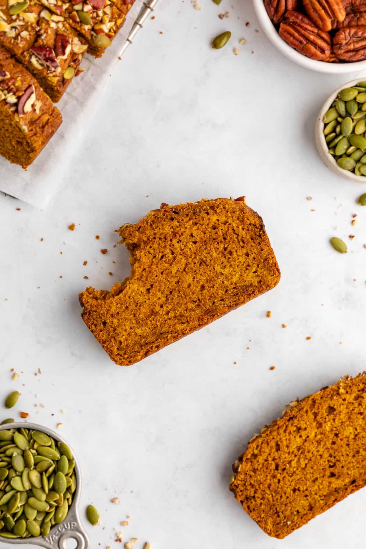 a slice of gluten-free vegan pumpkin bread with a bite taken out of it