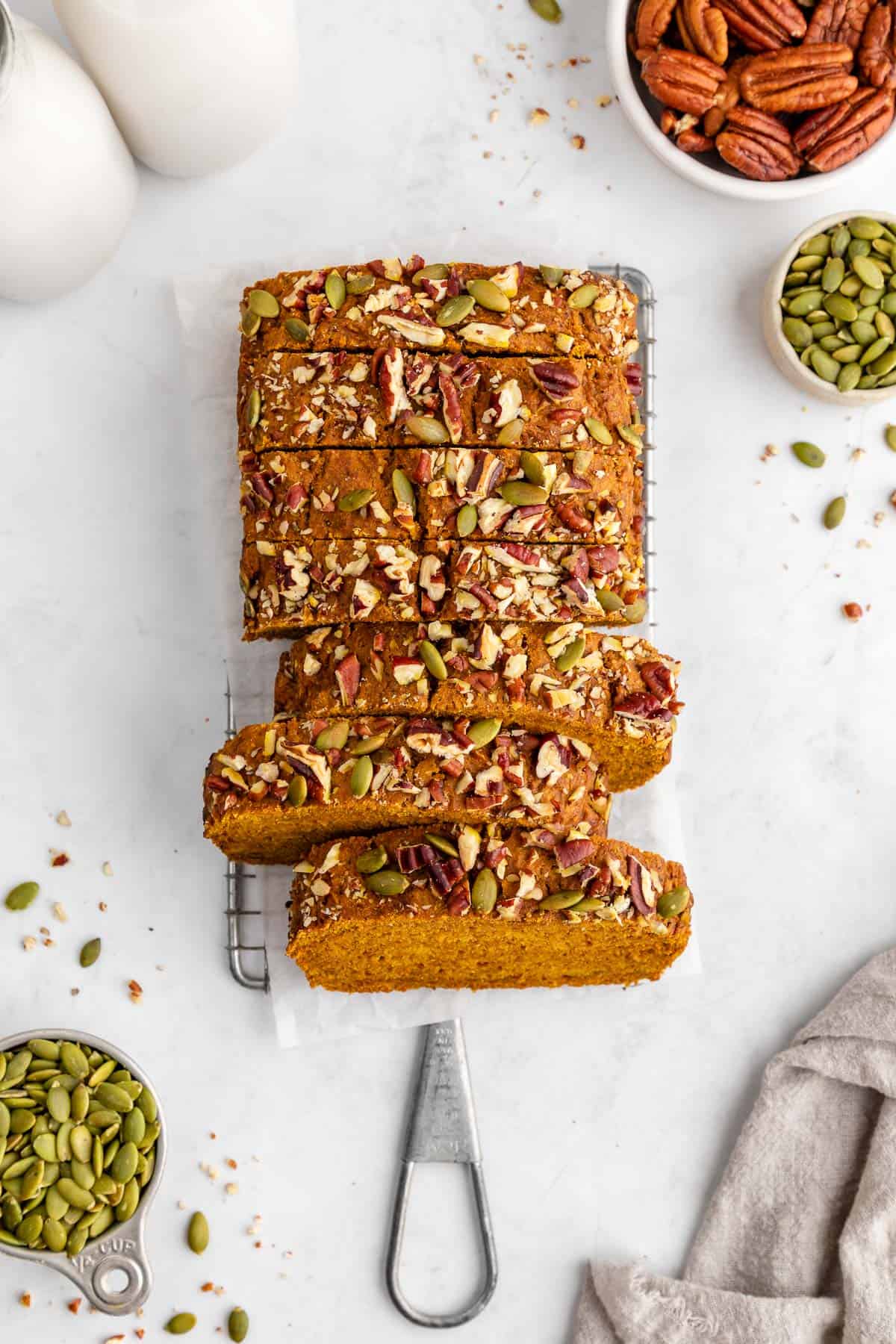 a sliced loaf of easy vegan pumpkin bread with pecans and pumpkin seeds