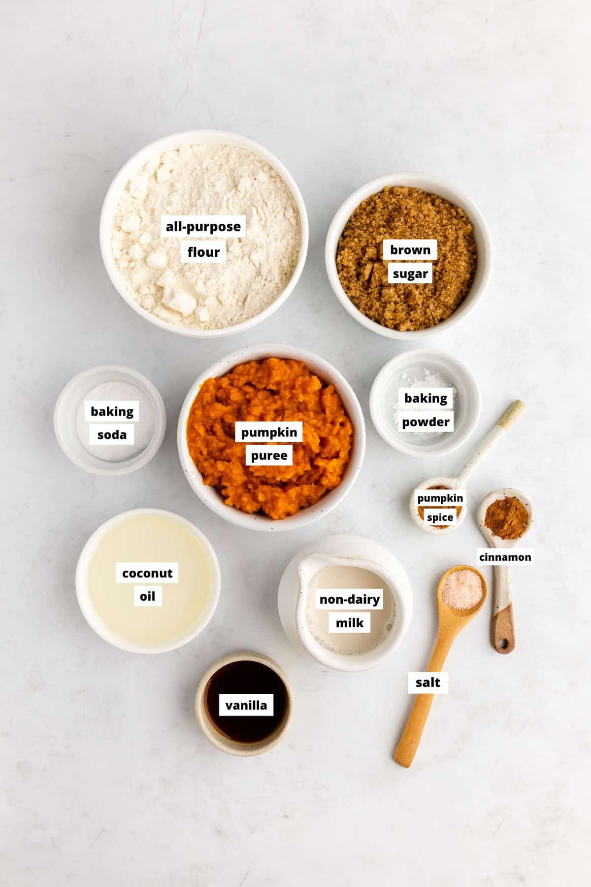 bowls of ingredients for vegan pumpkin bread including flour, pumpkin puree, brown sugar, and coconut oil