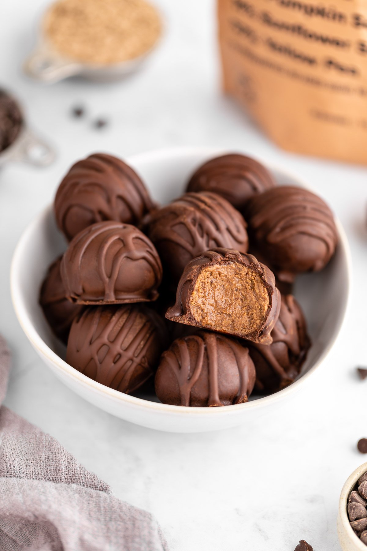 a bowl of chocolate protein truffles with a bite taken out of one