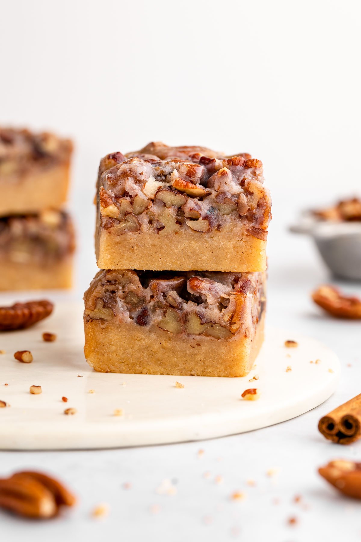 a stack of two vegan pecan pie bars with shortbread crust and sticky pecan topping