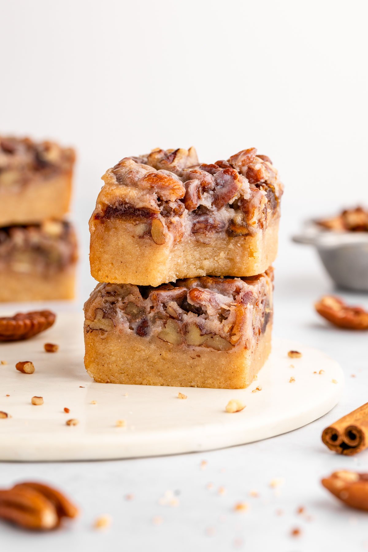 a stack of two vegan pecan pie bars with a bite taken out of the top one