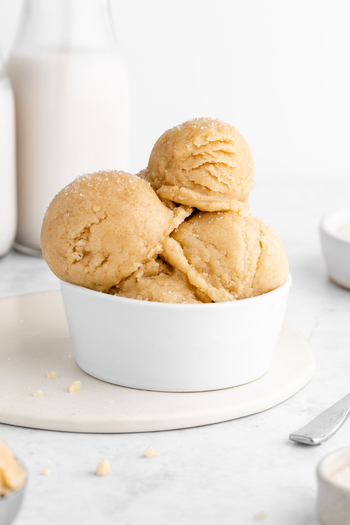 scoops of vegan edible sugar cookie dough stacked in a white bowl