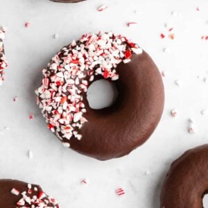 vegan peppermint mocha donuts with chocolate frosting and candy canes on top