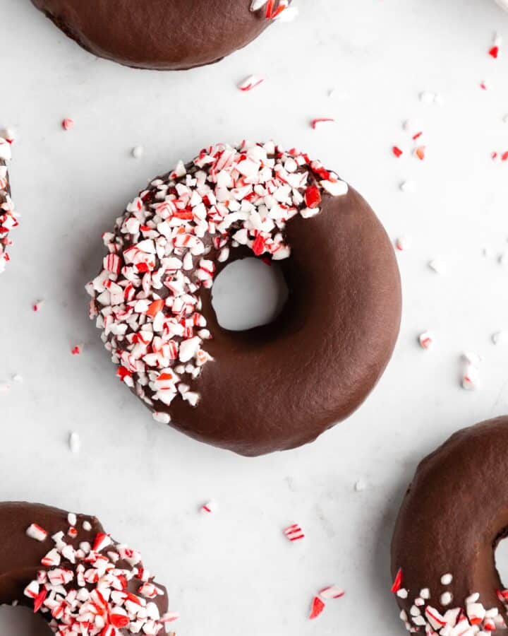 vegan peppermint mocha donuts with chocolate frosting and candy canes on top