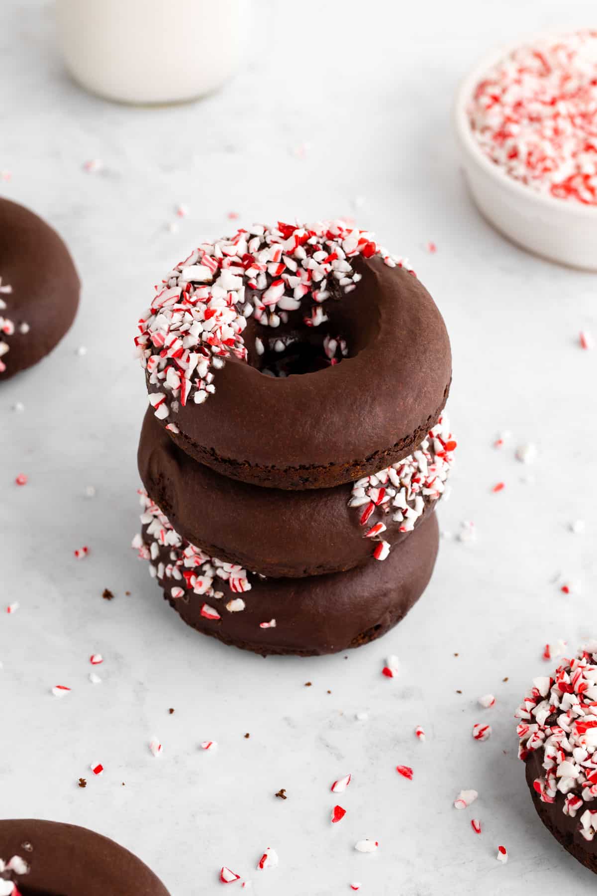 a stack of vegan chocolate peppermint mocha donuts with crushed candy canes