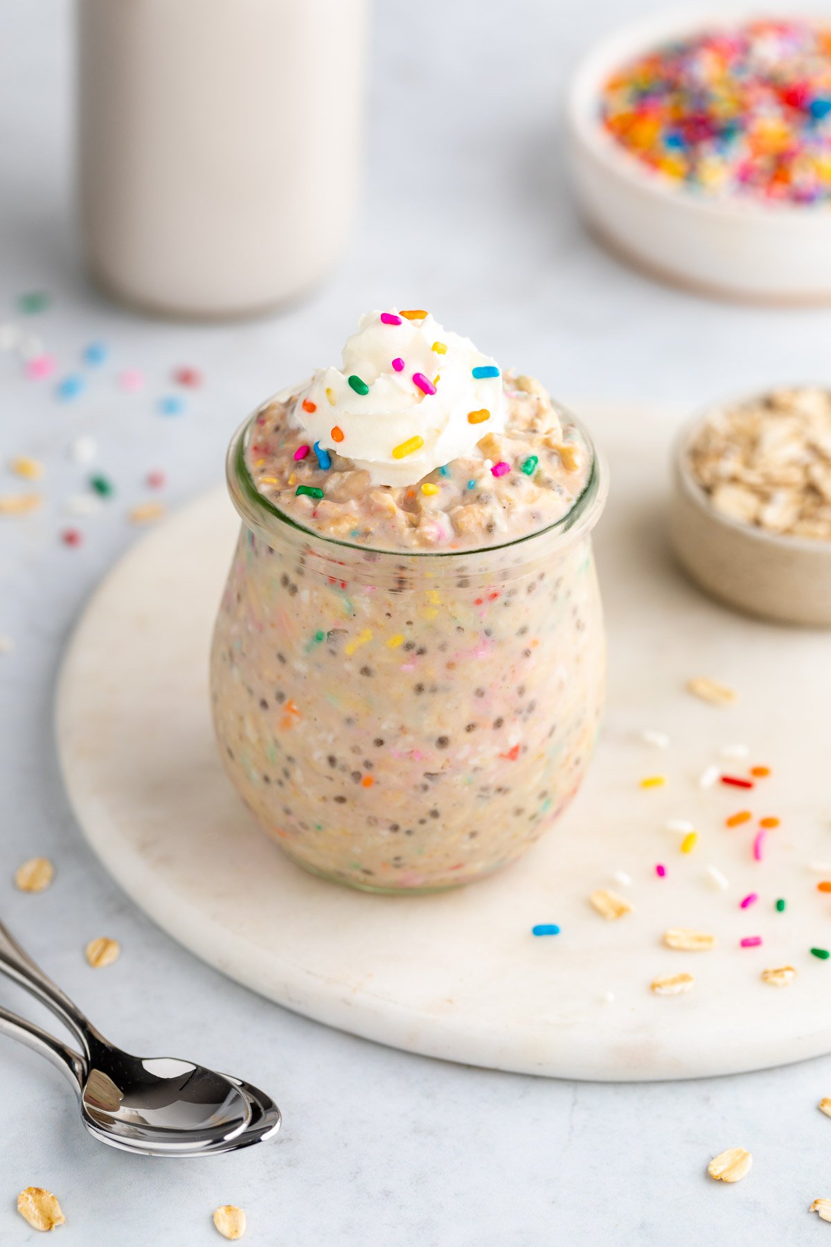 birthday cake overnight oats in a jar with sprinkles and whipped cream