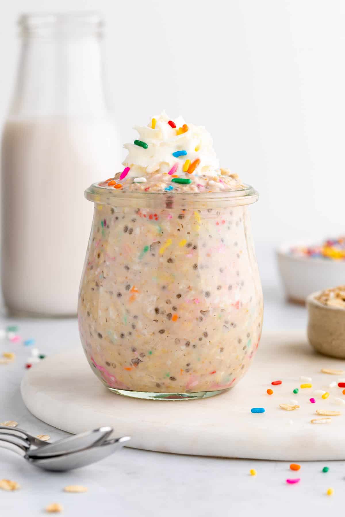 birthday cake overnight oats in a jar with sprinkles and whipped cream