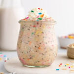 a jar of birthday cake overnight oats with sprinkles and whipped cream