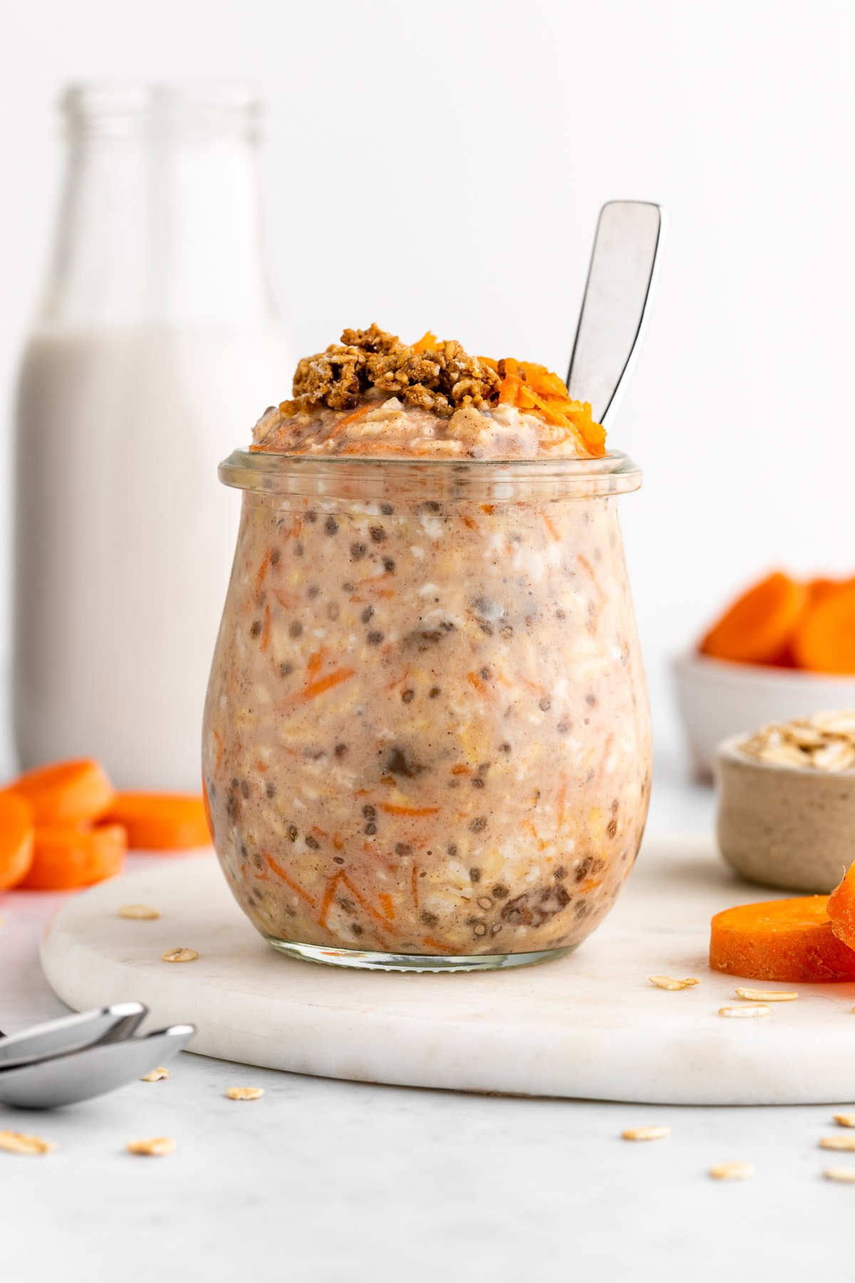 carrot cake overnight oats in a jar with a spoon inside it