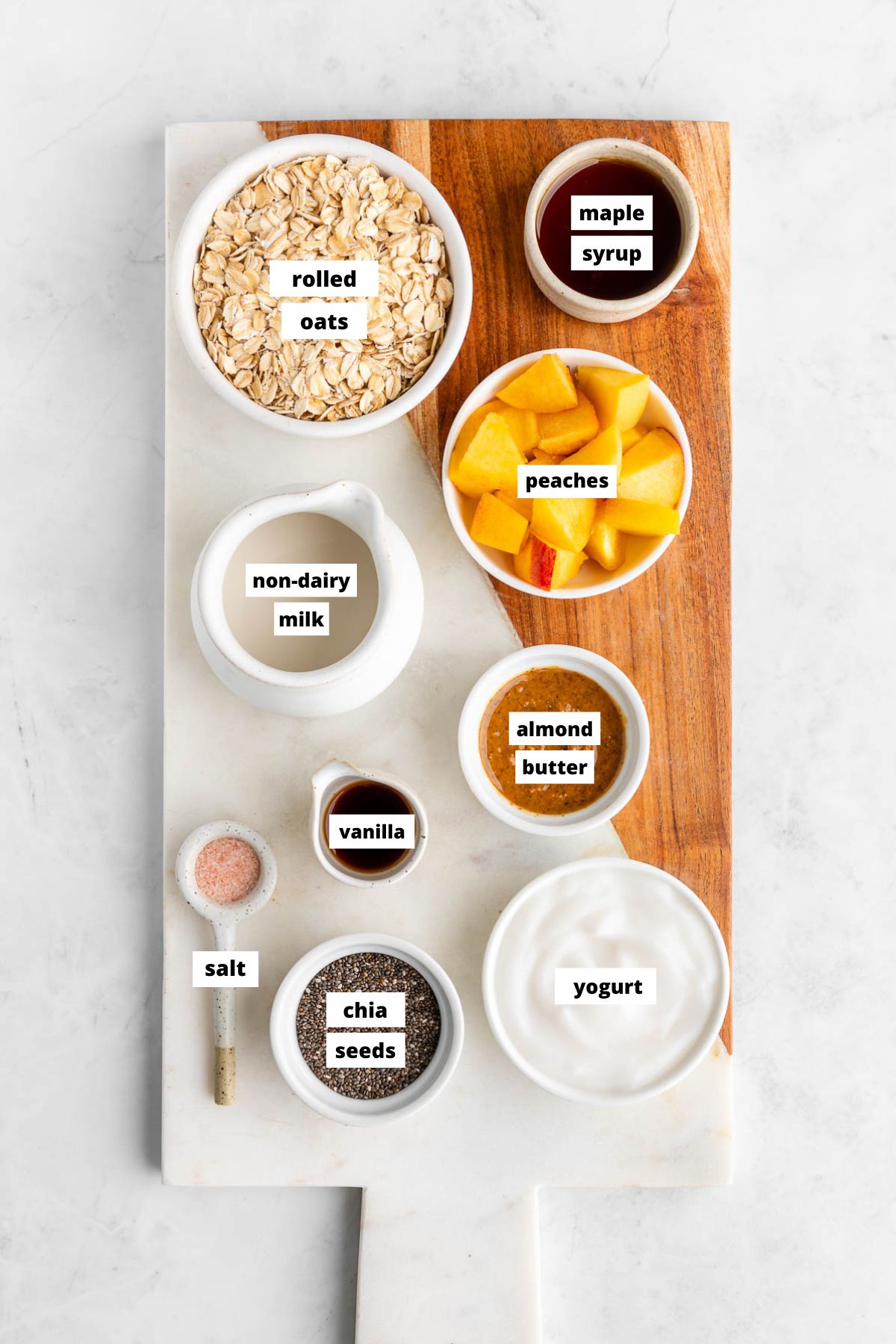 ingredients for peaches and cream overnight oats on a marble serving board