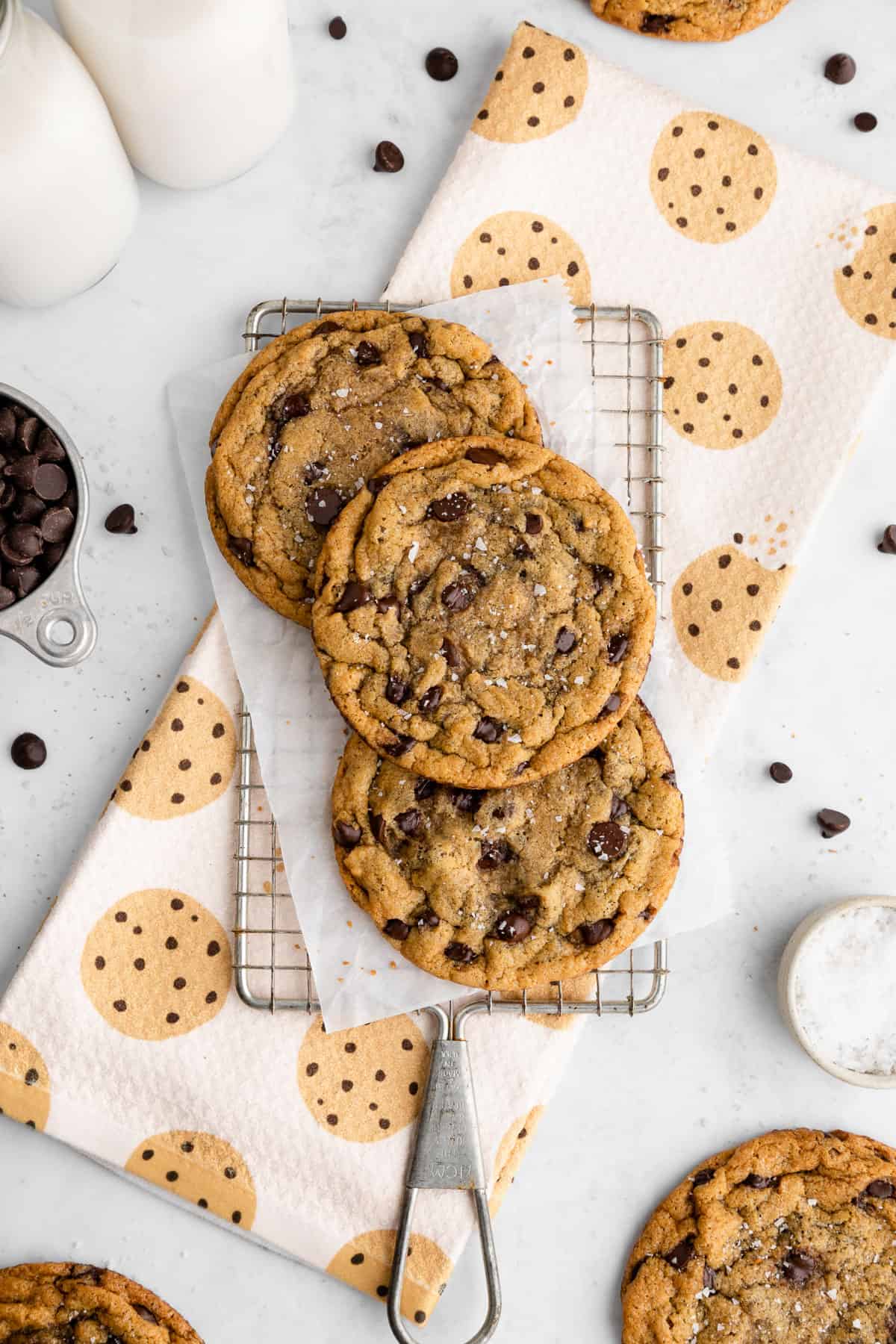 three chocolate chip cookies beside a geometry kitchen towel