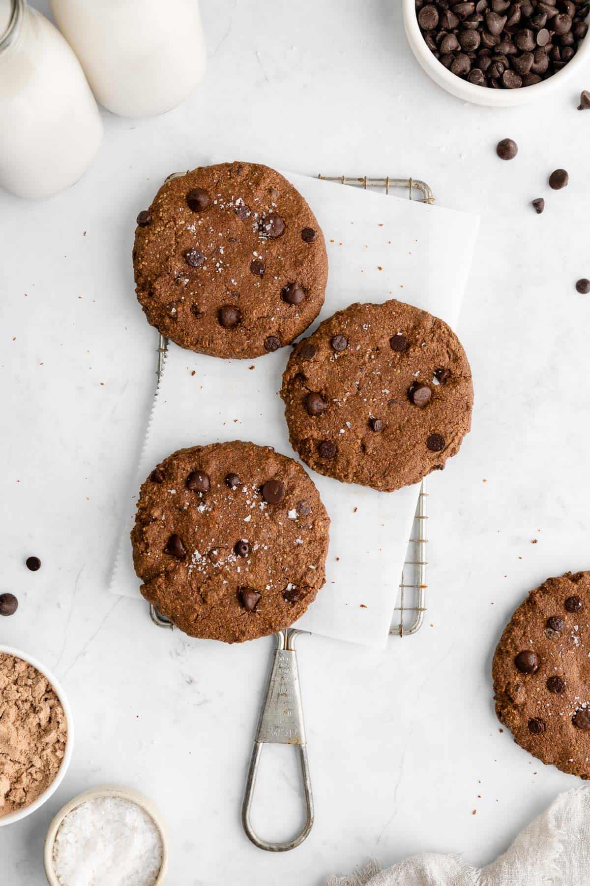 three vegan chocolate protein cookies on a wire baking rack