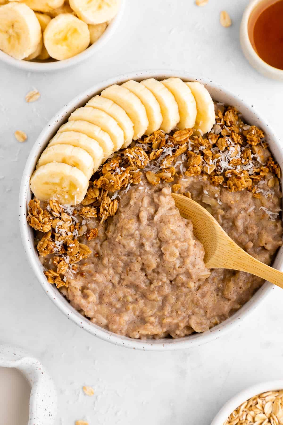 a wooden spoon scooping into a bowl of vegan banana oatmeal