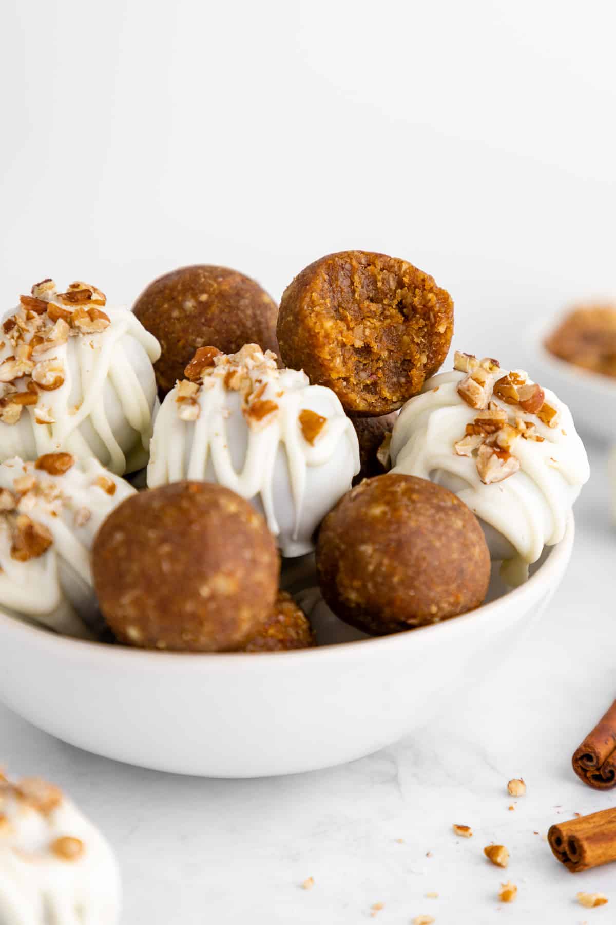a bowl of no-bake vegan carrot cake truffles covered in white chocolate