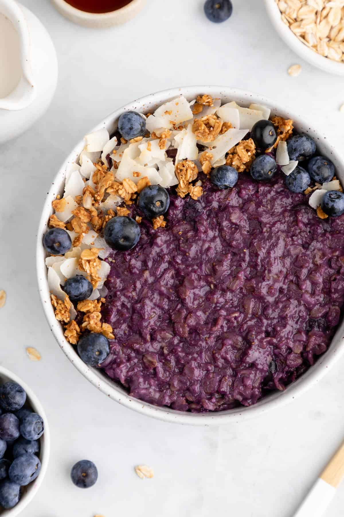 a close up of vegan blueberry oatmeal in a ceramic bowl