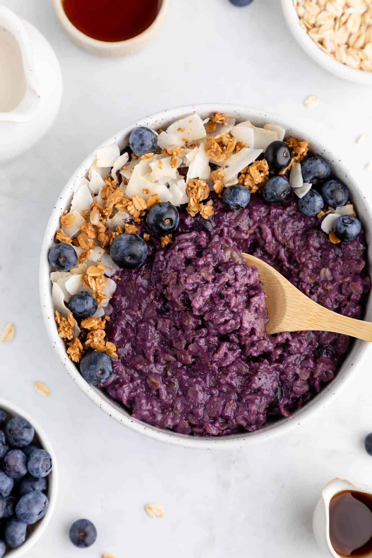 a wooden spoon scooping into a bowl of blueberry oatmeal