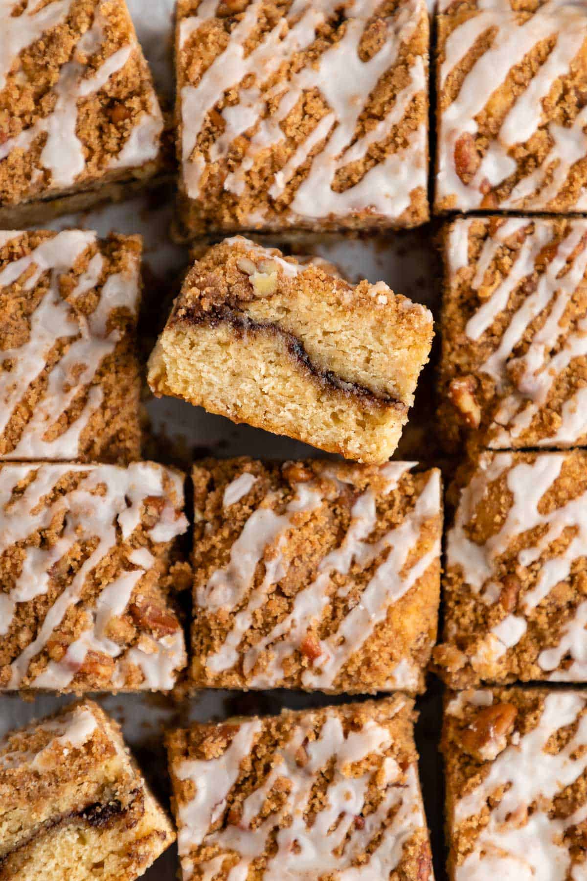 a close up pile of vegan cinnamon roll coffee cake with vanilla glaze