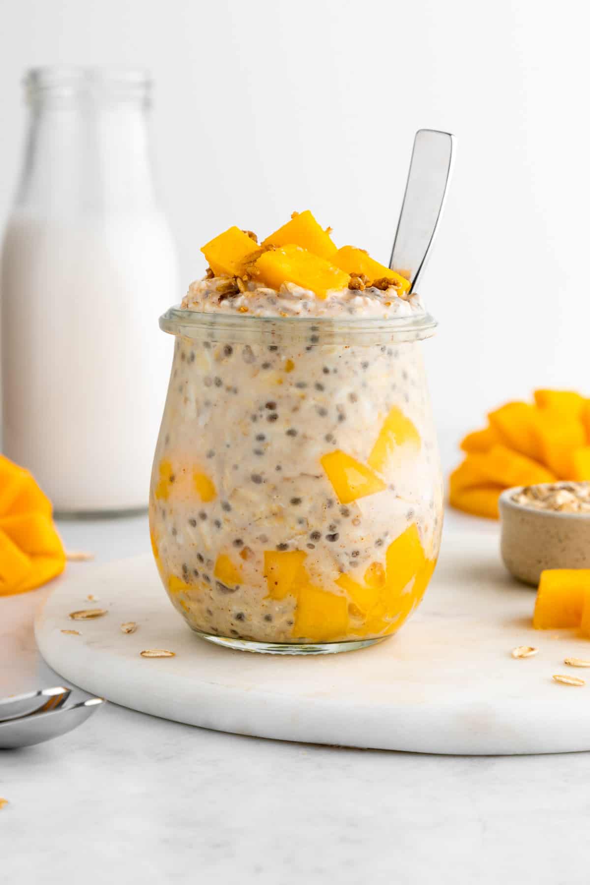 mango overnight oats inside a glass weck jar with a spoon