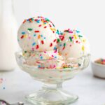three scoops of coconut milk cake batter ice cream inside a sundae glass