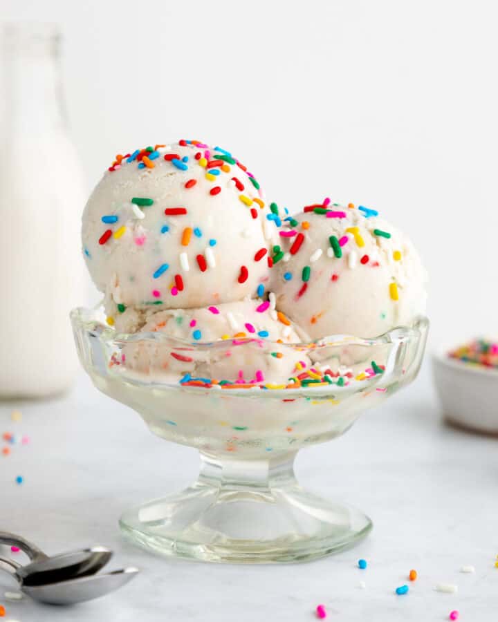 three scoops of coconut milk cake batter ice cream inside a sundae glass