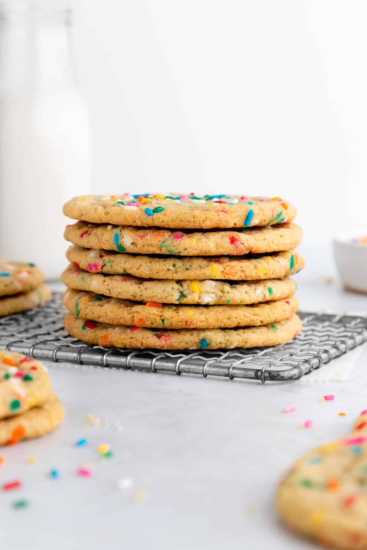 a stack of vegan funfetti cookies on a wire cooling rack
