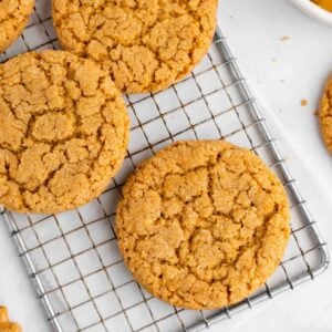 a pile of vegan peanut butter cookies on a wire rack