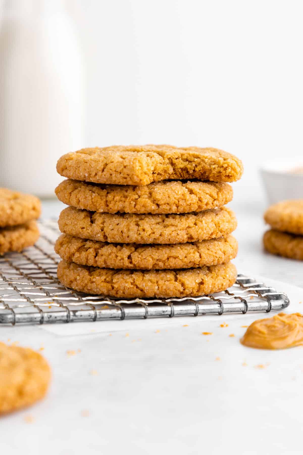 a stack of vegan peanut butter cookies with a bite taken out of the top cookie