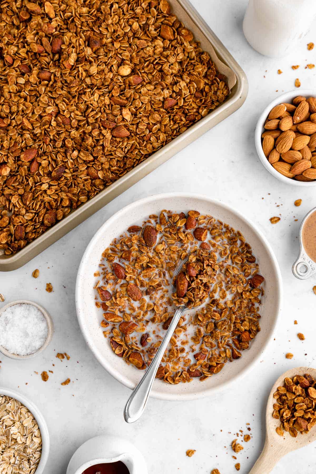 a baking sheet and a bowl filled with homemade almond butter granola