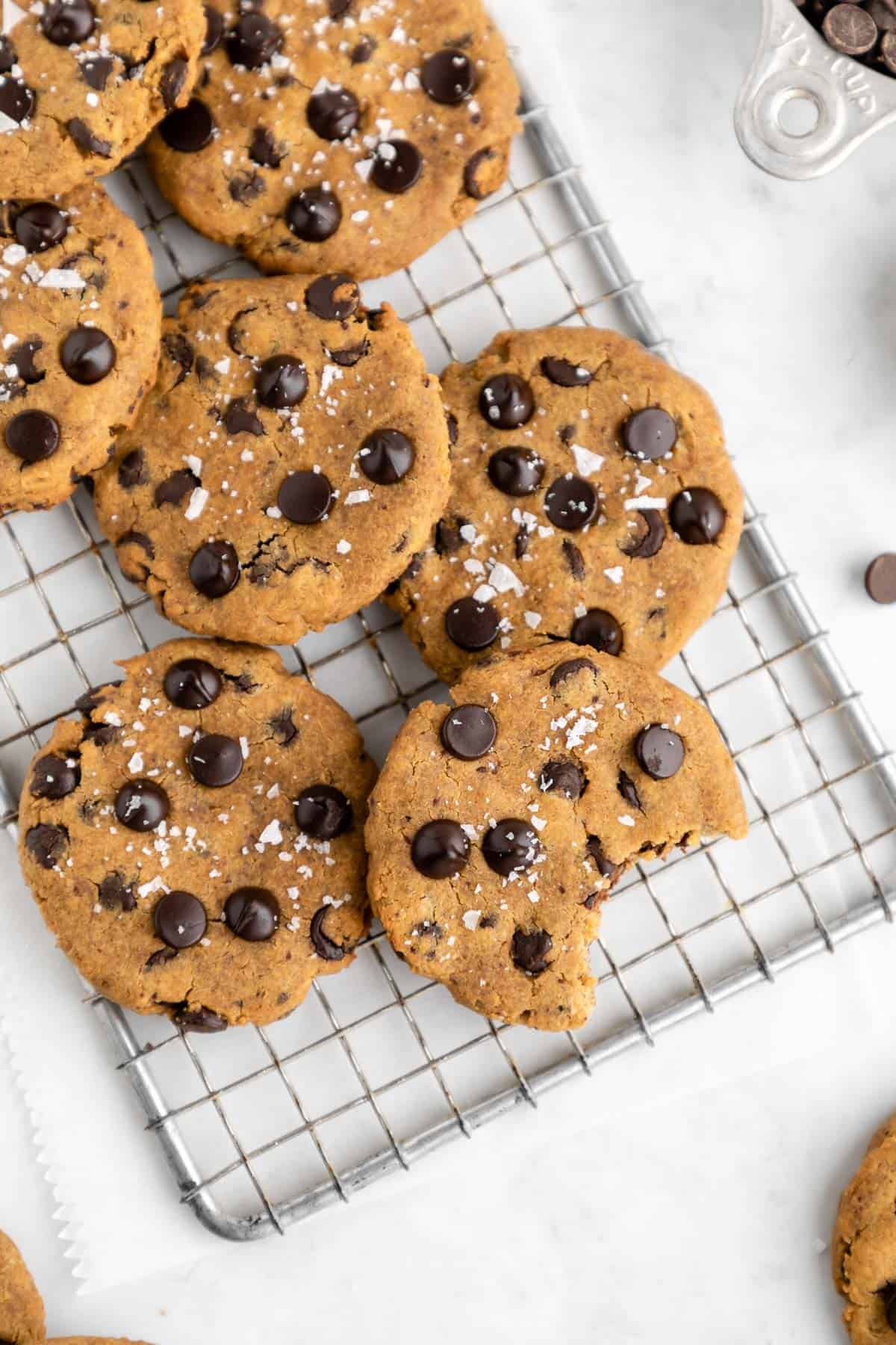 healthy chickpea chocolate chip cookies on a wire cooling rack with a bite taken out of one