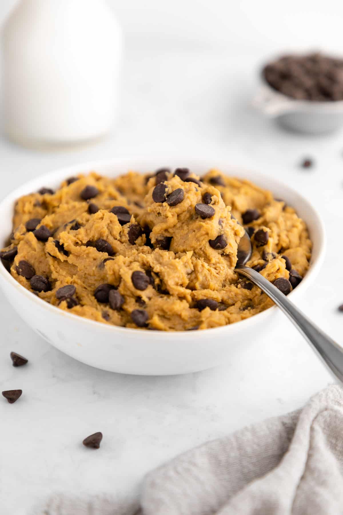 healthy chocolate chip chickpea cookie dough inside a bowl with a spoon