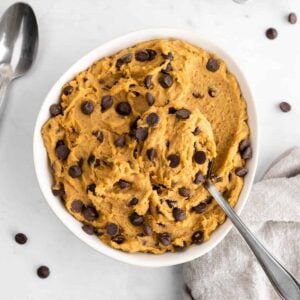 a spoon scooping into a bowl of chickpea cookie dough