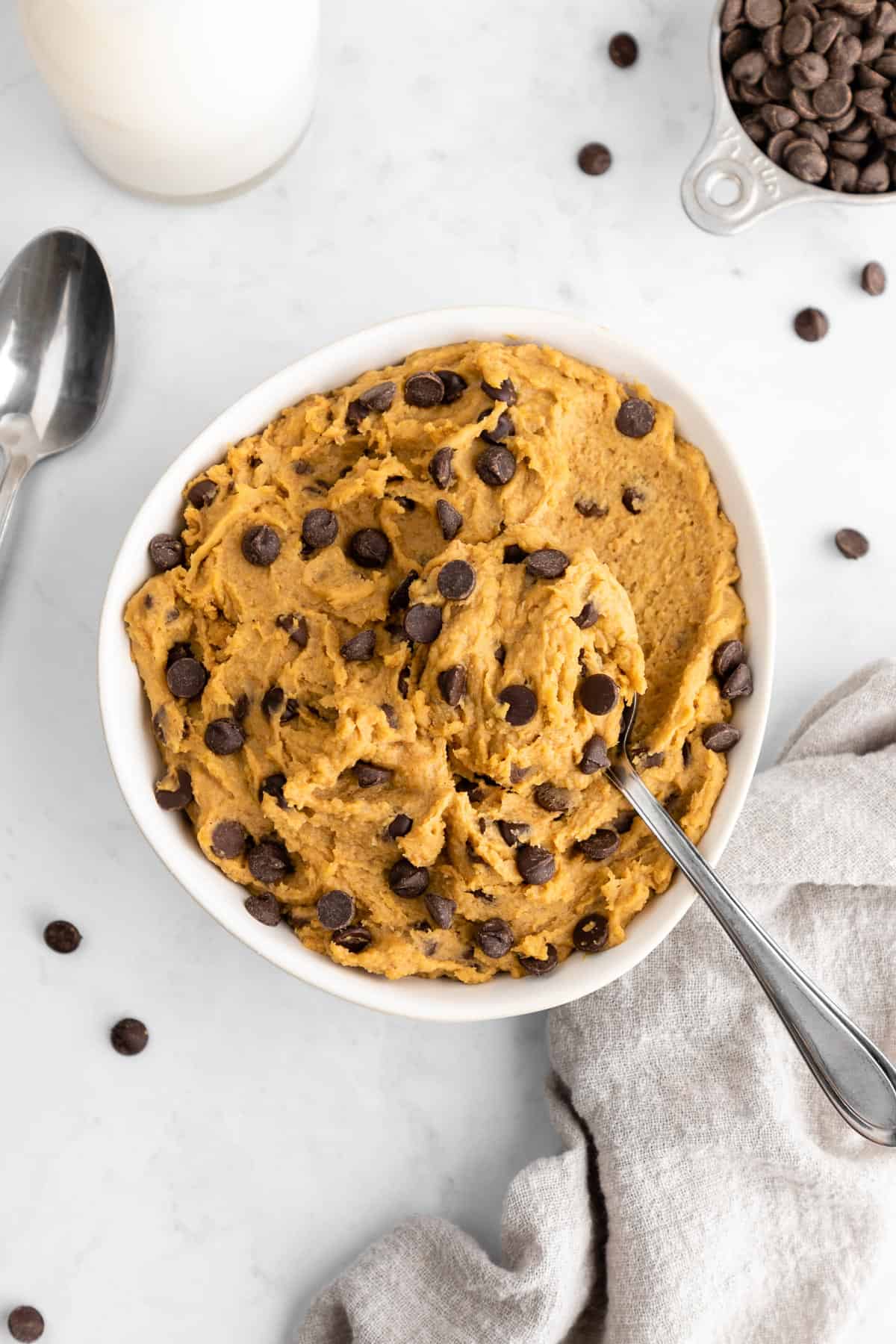 a spoon scooping into a bowl of chickpea cookie dough