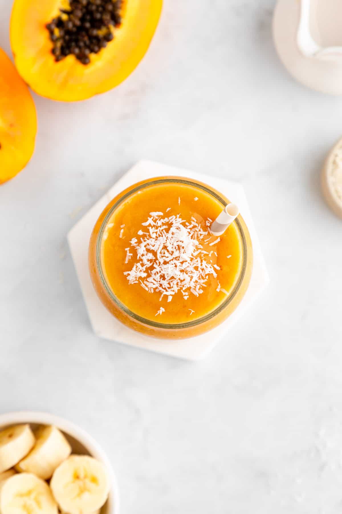 flatlay of a papaya banana smoothie inside a glass