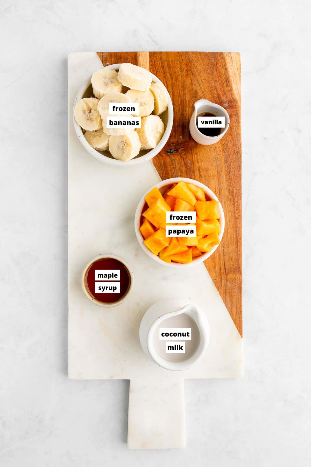 ingredients for a papaya banana smoothie on a marble serving board