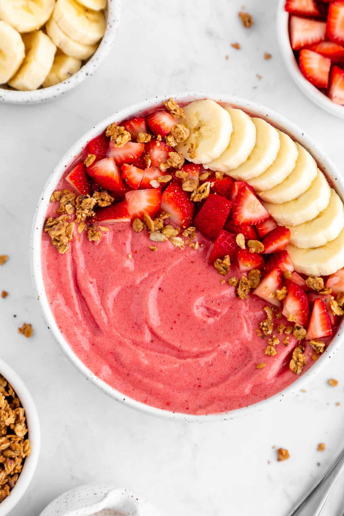 a close up photo of a strawberry banana smoothie bowl