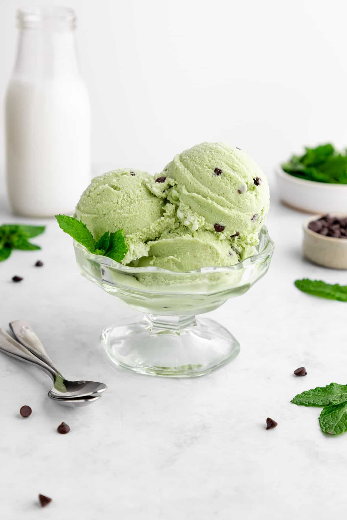 three scoops of vegan mint chocolate chip ice cream in a sundae glass