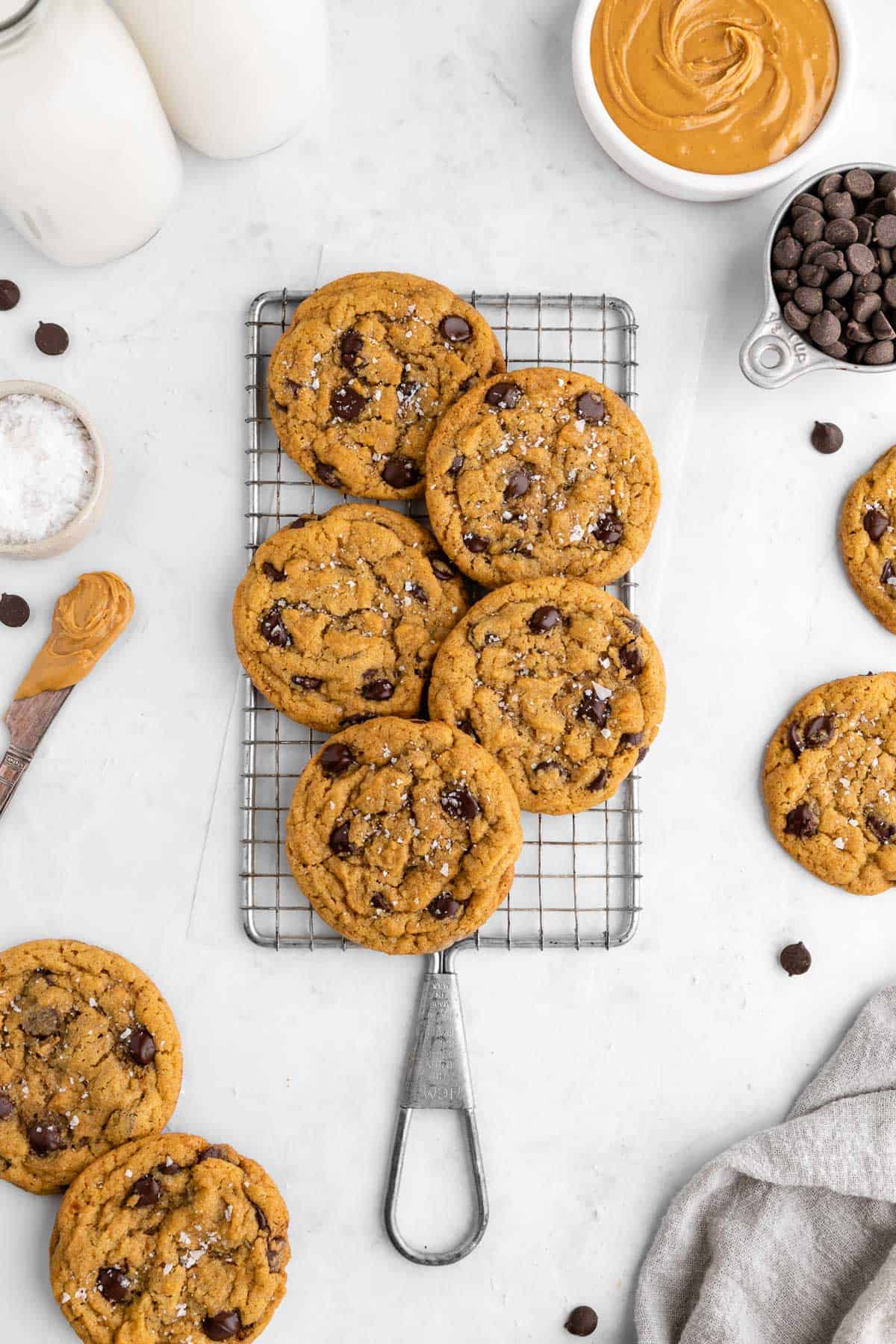 a pile of vegan peanut butter chocolate chip cookies on a wire cooling rack